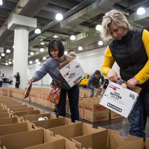 Volunteers distribute donated food into Thanksgiving meal boxes on Nov. 23, 2015 in New York City. The free meals were organized by the state government through a food drive and given to those in need for Thanksgiving. (Photo by Andrew Burton/Getty)
