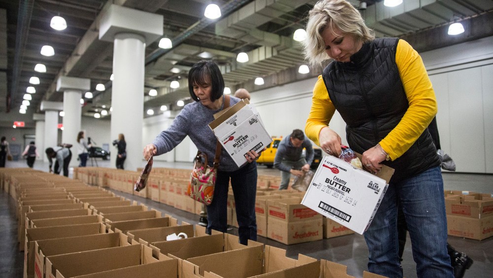 Volunteers distribute donated food into Thanksgiving meal boxes on Nov. 23, 2015 in New York City. The free meals were organized by the state government through a food drive and given to those in need for Thanksgiving. (Photo by Andrew Burton/Getty)