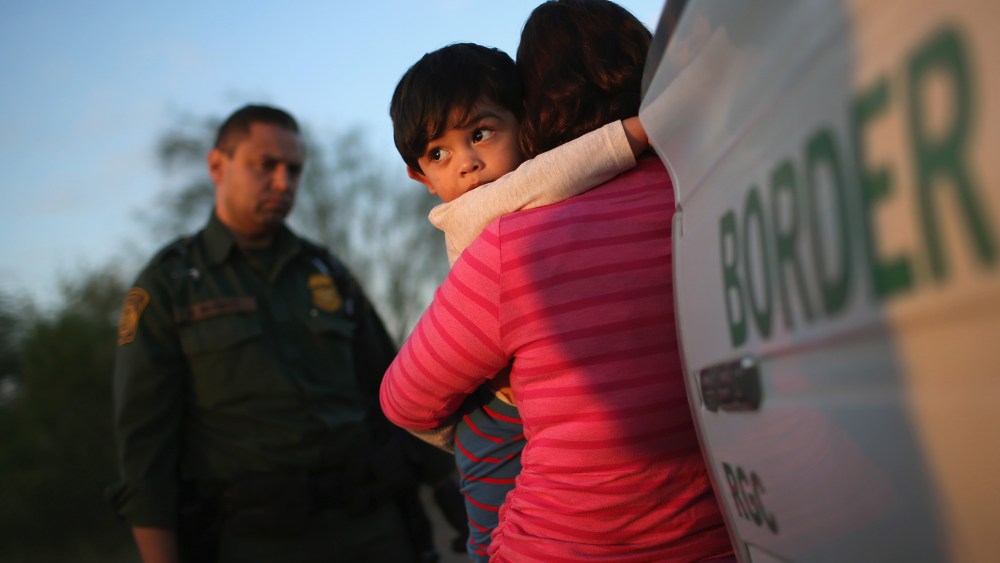 A one-year-old from El Salvador clings to his mother after they turned themselves in to Border Patrol agents after entering the country illegally on Dec. 7, 2015 near Rio Grande City, Texas. (Photo by John Moore/Getty)