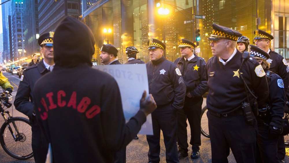 A demonstrator confronts police during a march through downtown on Dec. 12, 2015 in Chicago, Ill. (Photo by Scott Olson/Getty)