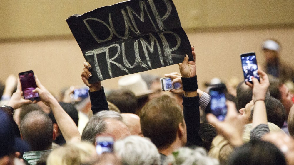 A protester's sign reads "Dump Trump" during a campaign rally for Donald Trump on Dec. 14, 2015. (Photo by Patrick T. Fallon/Bloomberg/Getty)