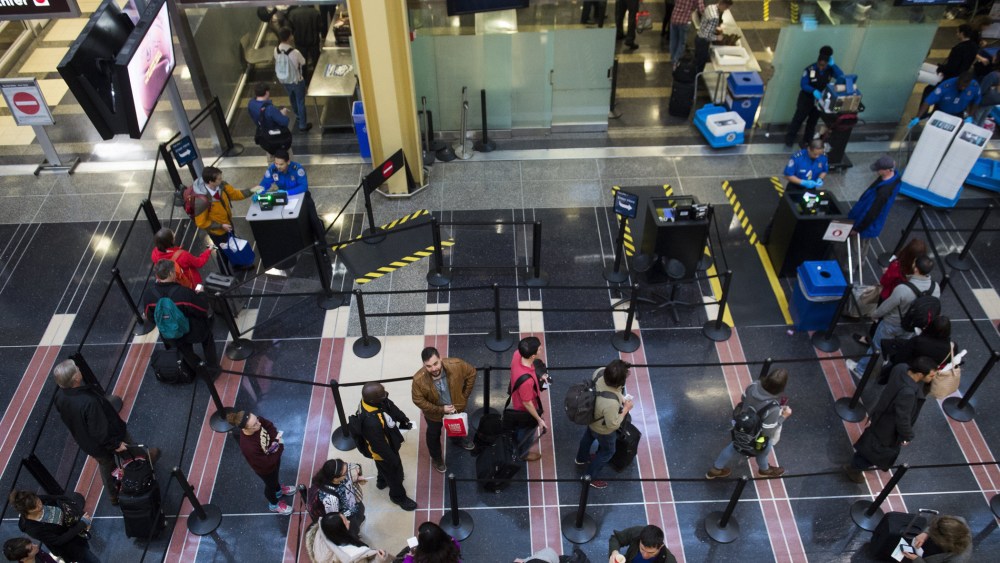 Passengers stand in line to go through a TSA security checkpoint as they head to their flights at Reagan National Airport in Arlington, Va., Dec. 23, 2015. (Photo by Saul Loeb/AFP/Getty)