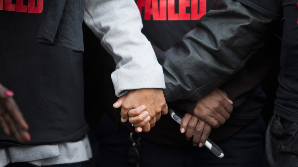 Janet Cooksey is comforted during a press conference about the deaths of her son Quintonio LeGrier, and Bettie Jones before the start of a vigil on Dec. 27, 2015 in Chicago, Ill. (Photo by Scott Olson/Getty)