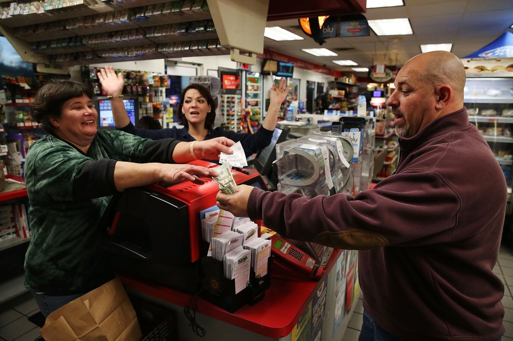Gale Call (L) and Sherrie Haines (C) sell a Powerball ticket to Mike Nastasi (R) at a BP gas station, Jan. 6, 2015 in Dunkirk, Md. (Photo by Mark Wilson/Getty)
