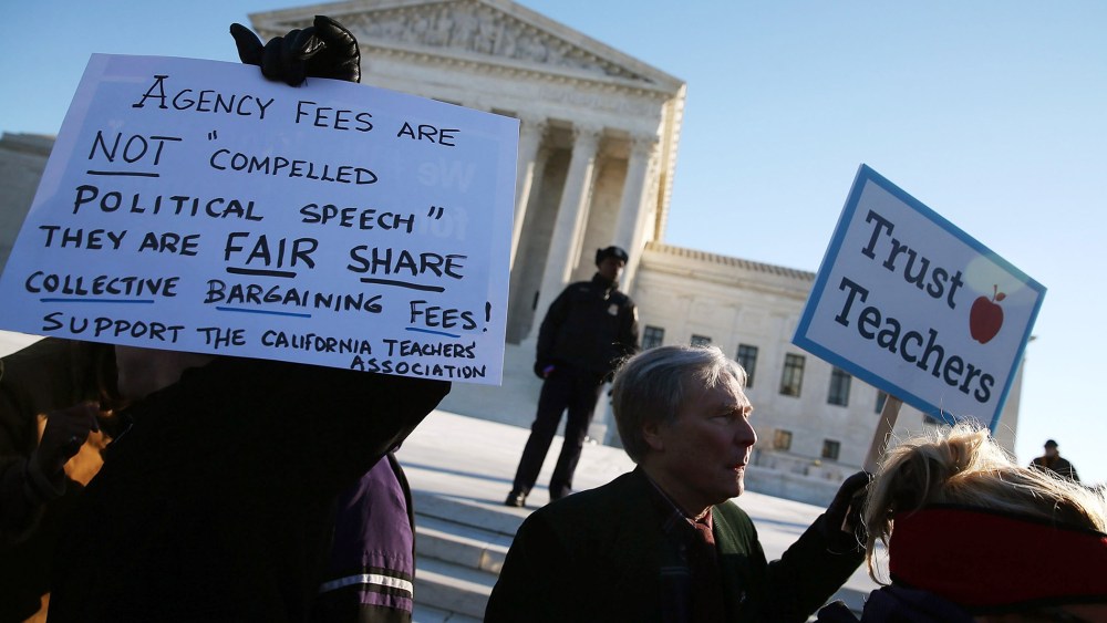 People for and against unions hold up signs in front of the US Supreme Court building Jan. 11, 2016 in Washington, DC. (Photo by Mark Wilson/Getty)