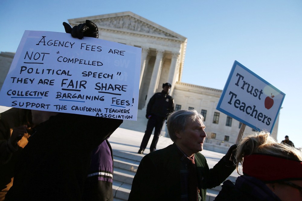 People for and against unions hold up signs in front of the US Supreme Court building Jan. 11, 2016 in Washington, DC. (Photo by Mark Wilson/Getty)