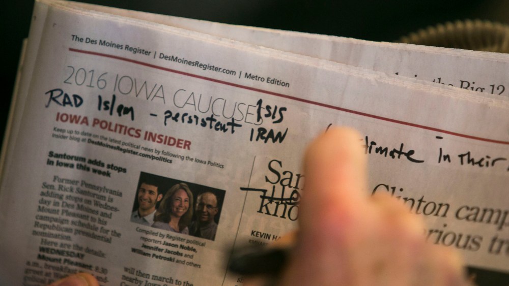 A man writes takes notes while listening to republican presidential candidate Rick Santorum speaks at a town hall style campaign stop at the BrownWinick Law Firm in Des Moines, Ia., Jan. 13, 2016. (Photo By Al Drago/CQ Roll Call/Getty)