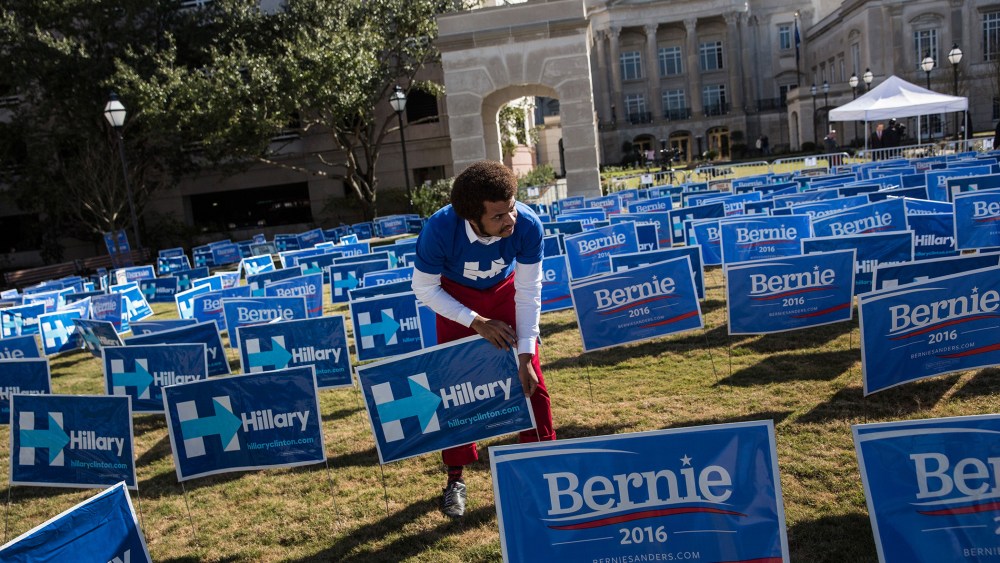A man places signs supporting Hillary Clinton for the democratic presidential nominee outside the Gaillar Center prior to tonight's Democratic debate on Jan. 17, 2016 in Charleston, S.C. (Photo by Andrew Burton/Getty)