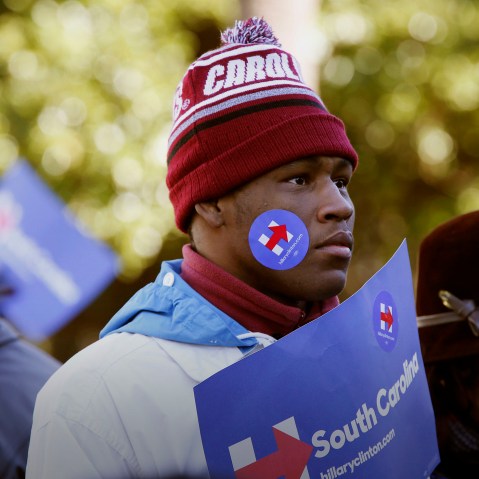 An attendee decked in Hillary Clinton campaign merchandise listens during an event on the front steps of the State House in Columbia, S.C., Jan. 18, 2016. (Photo by Patrick T. Fallon/Bloomberg/Getty)