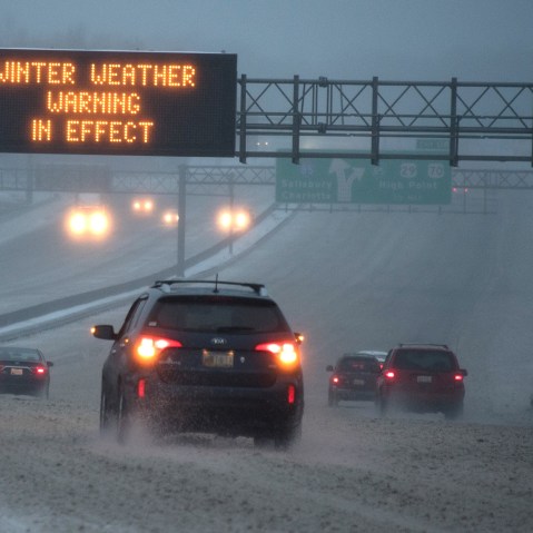 Vehicles move along Interstate 85 as an overhead sign indicates 'WINTER WEATHER WARNING IN EFFECT' during a winter storm on Jan. 22, 2016 in Greensboro, N.C. (Photo by Lance King/Getty)