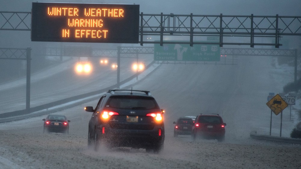 Vehicles move along Interstate 85 as an overhead sign indicates 'WINTER WEATHER WARNING IN EFFECT' during a winter storm on Jan. 22, 2016 in Greensboro, N.C. (Photo by Lance King/Getty)