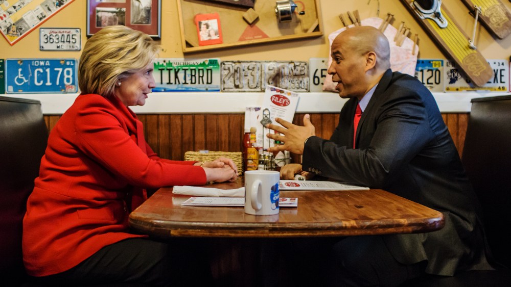 Democratic presidential candidate Hillary Clinton talks with Sen. Cory Booker (D-NJ) at Riley's Cafe on Jan. 24, 2016 in Cedar Rapids, Iowa. (Photo by Brendan Hoffman/Getty)