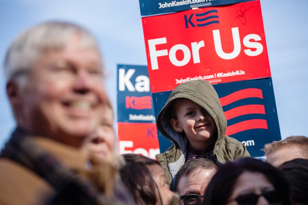 A child listens to Republican presidential candidate John Kasich speak to campaign workers and volunteers outside his campaign headquarters in Manchester, N.H., Feb. 6, 2016. (Photo by Matthew Cavanaugh/Getty)