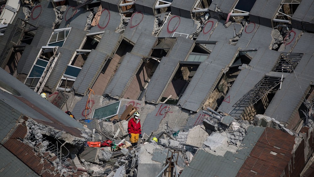 Rescue worker search for victim at a collapsed building on Feb. 7, 2016 in Tainan, Taiwan. A magnitude 6.4 earthquake hit southern Taiwan early Saturday, killing at least fourteen people, and leaving over one hundred missing. (Photo by Lam Yik Fei/Getty)