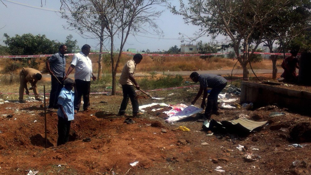 Indian authorities inspect the site of a suspected meteorite landing on Feb. 7, 2016 in Vellore district in southern Tamil Nadu state. The impact of the meteorite killed a bus driver and injured three others on Feb. 6. (Photo by STR/AFP/Getty)