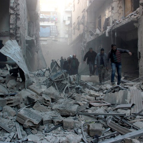People walk past the rubbles as Russian airstrikes pound residential areas at opposition controlled Salihin neighborhood of Aleppo, Syria on Feb. 8, 2016. (Photo by Ibrahim Ebu Leys/Anadolu Agency/Getty)