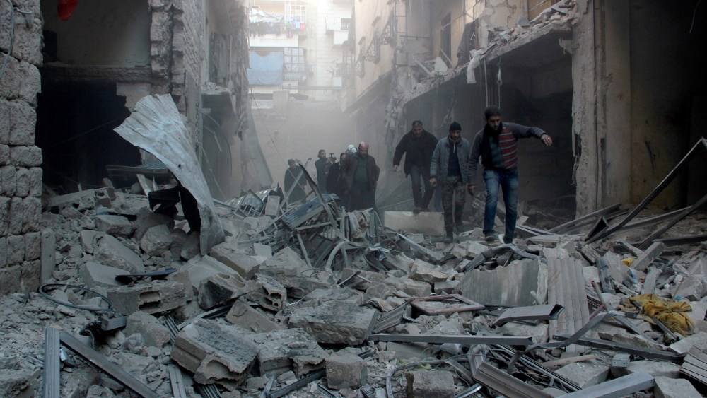 People walk past the rubbles as Russian airstrikes pound residential areas at opposition controlled Salihin neighborhood of Aleppo, Syria on Feb. 8, 2016. (Photo by Ibrahim Ebu Leys/Anadolu Agency/Getty)