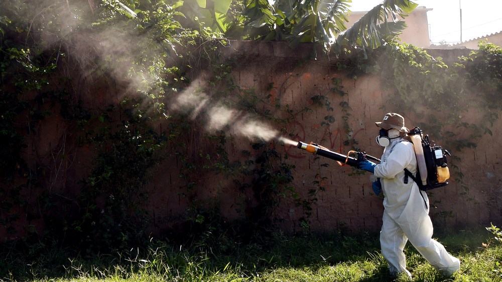 A member of the National Health Foundation fumigates against the Aedes aegypti mosquito, vector of the dengue, chikungunya fever and zika viruses, in Gama, Brazil, Feb. 17, 2016. (Photo by Evaristo SA/AFP/Getty)