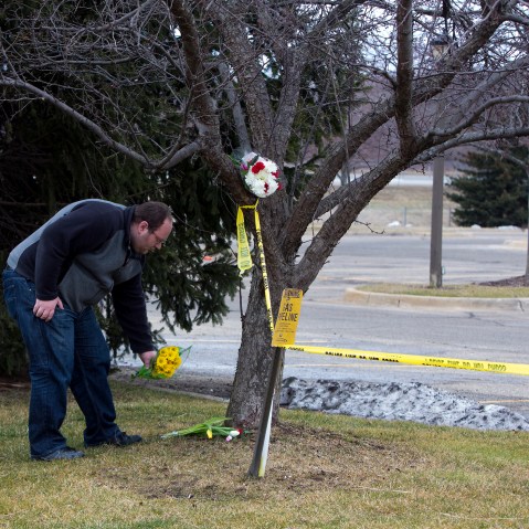 A man places flowers at a Cracker Barrel where a gunman went on a shooting rampage, on Feb. 21, 2016 in Kalamazoo, Mich. (Photo by Tasos Katopodis/Getty)