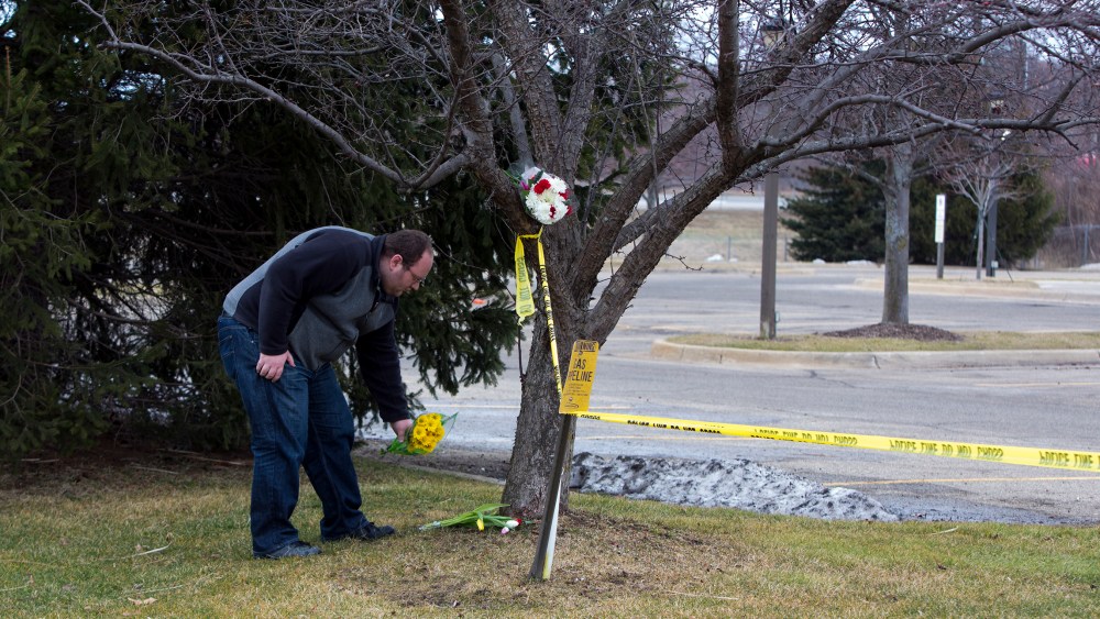 A man places flowers at a Cracker Barrel where a gunman went on a shooting rampage, on Feb. 21, 2016 in Kalamazoo, Mich. (Photo by Tasos Katopodis/Getty)