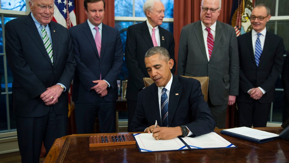 President Barack Obama, flanked by lawmakers and supporters of the bill, signs H.R. 1428 during a ceremony in the Oval Office of the White House on Feb. 24, 2016 in Washington, DC. (Photo by Shawn Thew/Pool/Getty)