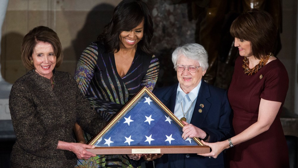 House Minority Leader Nancy Pelosi (D-CA) and First Lady Michelle Obama present an American flag to retired Air Force Brigadier Gen. Wilma Vaught on Capitol Hill, March 2, 2016 in Washington, DC. (Photo by Drew Angerer/Getty)