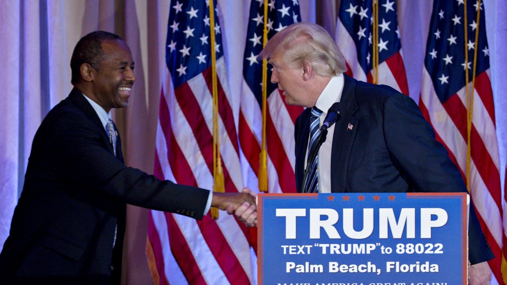 Donald Trump shakes hands with Ben Carson, retired neurosurgeon and former 2016 Republican presidential candidate, during a news conference at the Mar-A-Lago Club in Palm Beach, Fl., March 11, 2016. (Photo by Andrew Harrer/Bloomberg/Getty)
