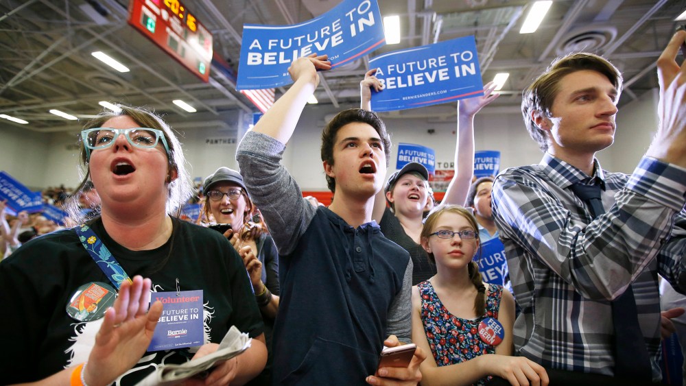 Supporters wave signs as Democratic presidential candidate Bernie Sanders speaks during a campaign rally at West High School on March 21, 2016 in Salt Lake City, Utah. (Photo by George Frey/Getty)