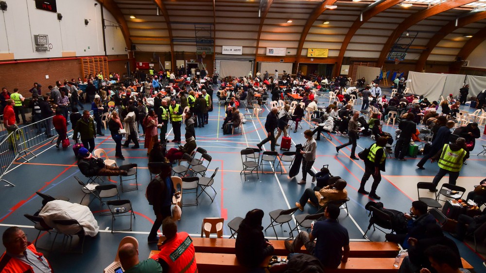 Travellers who were evacuated from Brussels airport take shelter at a sports complex in Zaventem following blasts on March 22, 2016. (Photo by John Thys/AFP/Getty)