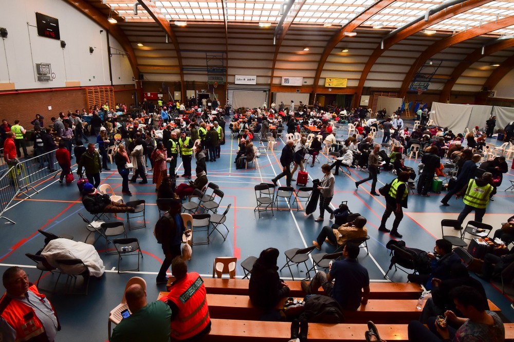 Travellers who were evacuated from Brussels airport take shelter at a sports complex in Zaventem following blasts on March 22, 2016. (Photo by John Thys/AFP/Getty)