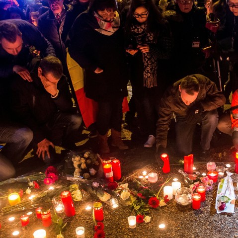 Brussels airport workers and their relatives place candles at a makeshift memorial as they pay tribute to the victims of Brussels triple attacks near the airport in Zaventem on March 23, 2016. (Photo by Philippe Huguen/AFP/Getty)
