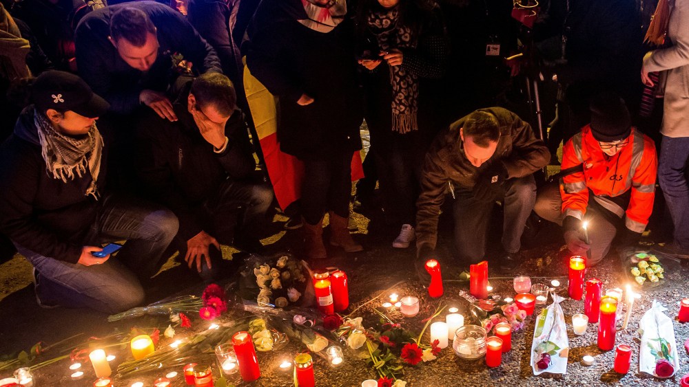 Brussels airport workers and their relatives place candles at a makeshift memorial as they pay tribute to the victims of Brussels triple attacks near the airport in Zaventem on March 23, 2016. (Photo by Philippe Huguen/AFP/Getty)