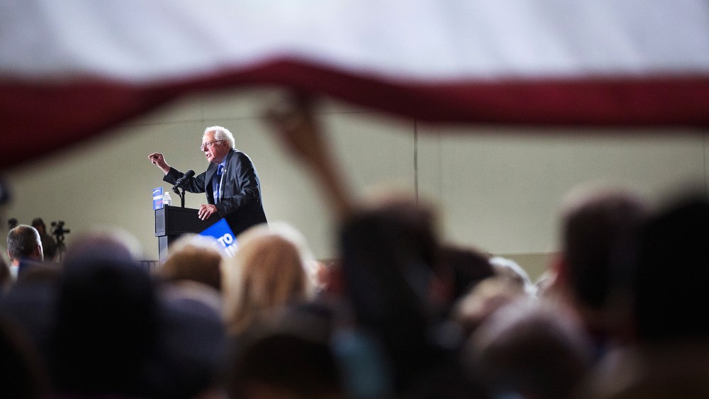 Guests lift up a giant flag to watch Democratic presidential candidate Senator Bernie Sanders (D-VT) speak at a campaign rally at the Alliant Energy Center on March 26, 2016 in Madison, Wis. (Photo by Scott Olson/Getty)