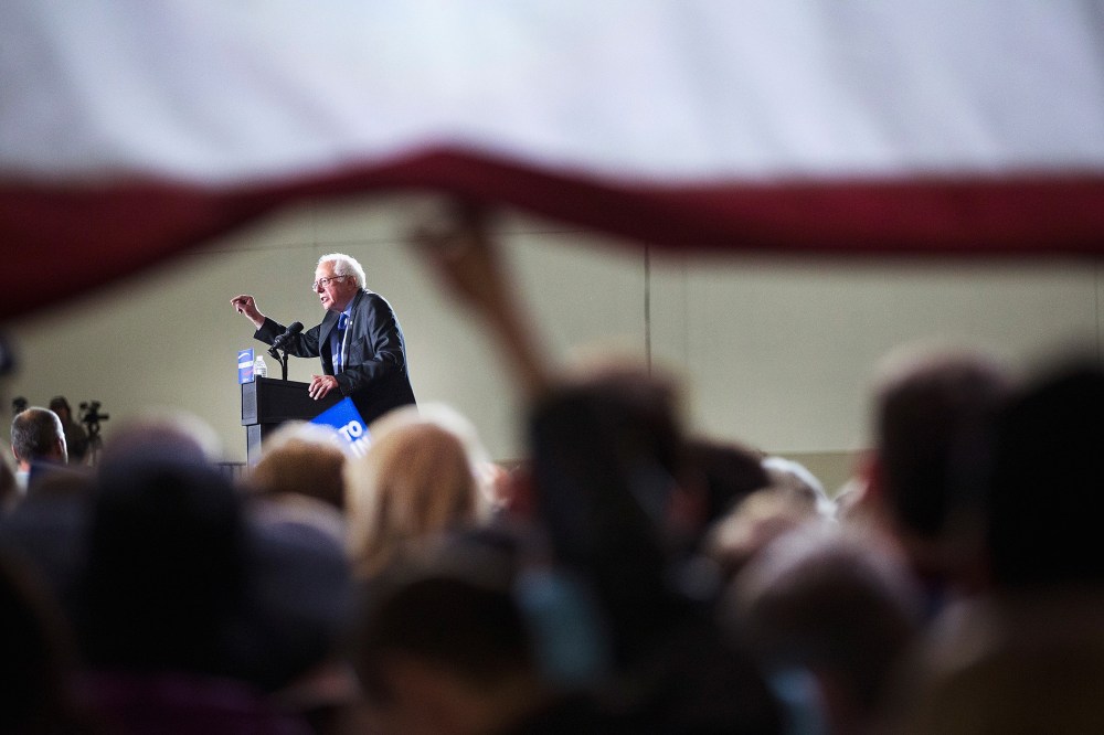 Guests lift up a giant flag to watch Democratic presidential candidate Senator Bernie Sanders (D-VT) speak at a campaign rally at the Alliant Energy Center on March 26, 2016 in Madison, Wis. (Photo by Scott Olson/Getty)