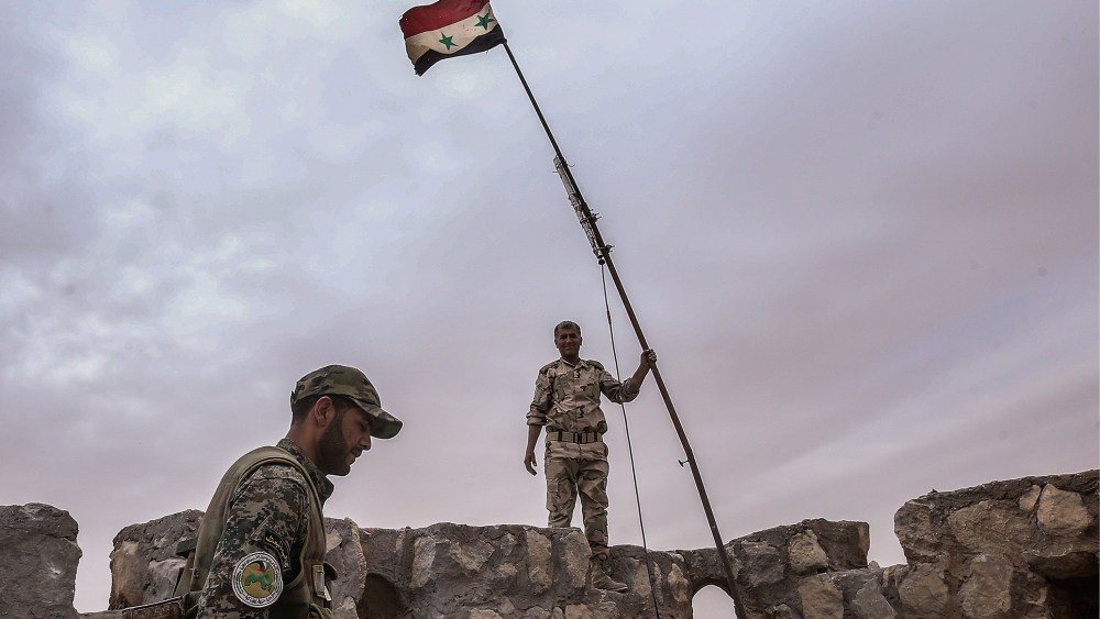Syrian government army soldiers put a flag on top of Fakhr al-Din al-Maani Citadel, a UNESCO world heritage site. The Syrian Government's army has won control of the heritage site from ISIS militants. (Photo by Valery Sharifulin/TASS/Getty)