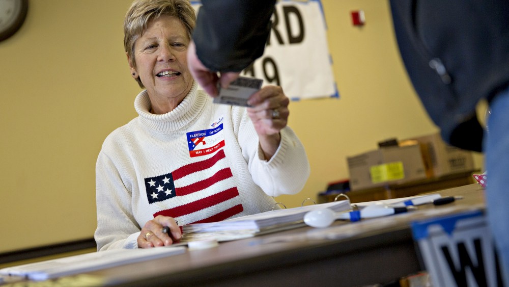 A poll worker checks the identification of a resident at polling location during the presidential primary vote in Waukesha, Wis., April 5, 2016. (Photo by Daniel Acker/Bloomberg/Getty)