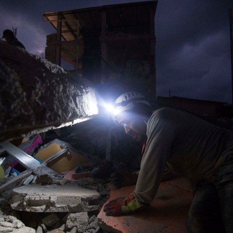 A rescue worker searches in the rubbles after an earthquake struck Ecuador on April 17, 2016 in El Carmen. At least 235 people were killed after a 7.8-magnitude quake. (Photo by Edu Leon/LatinContent/Getty)