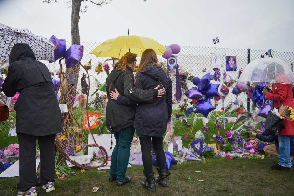 Two Prince fans embrace in front of the memorial outside Paisley Park on April 24, 2016 in Chanhassen, Minn. (Photo by Jules Ameel/Getty)
