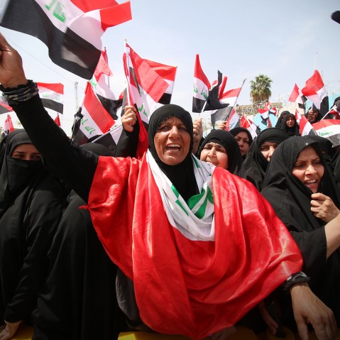 Iraqi supporters of the Sadrist movement hold national flags and shout slogans during a demonstration outside Baghdad's Green Zone on April 26, 2016. (Photo by Haidar Mohammed ALI/AFP/Getty)