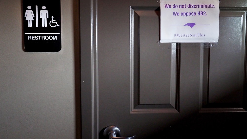 A unisex sign and the "We Are Not This" slogan are outside a bathroom at Bull McCabes Irish Pub on May 10, 2016 in Durham, N.C. (Photo by Sara D. Davis/Getty)