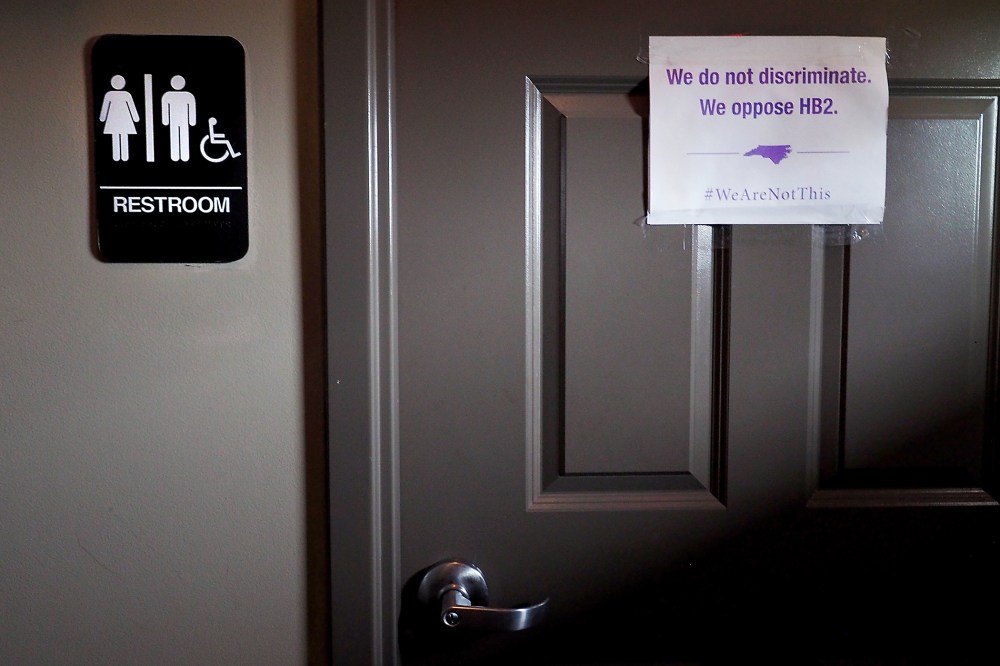 A unisex sign and the "We Are Not This" slogan are outside a bathroom at Bull McCabes Irish Pub on May 10, 2016 in Durham, N.C. (Photo by Sara D. Davis/Getty)