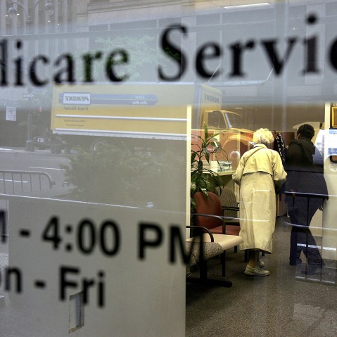 Two people walk inside a Medicare Services office. (Photo by Spencer Platt/Getty)