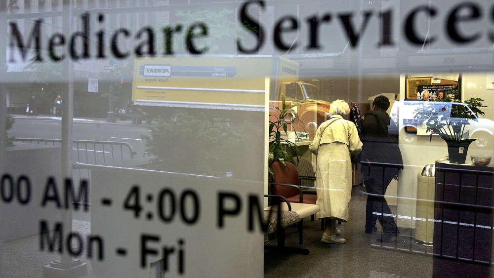 Two people walk inside a Medicare Services office. (Photo by Spencer Platt/Getty)