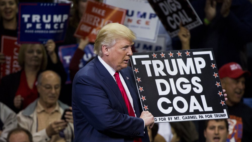 Republican presidential nominee Donald Trump holds a sign supporting coal during a rally at Mohegan Sun Arena in Wilkes-Barre, Pennsylvania on October 10, 2016.