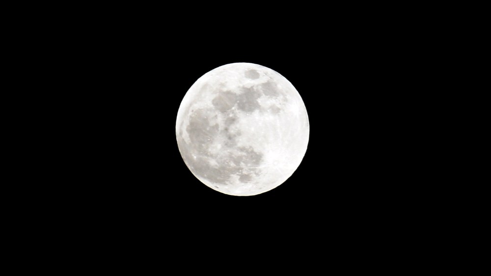 A full moon sits in the nights sky. (Photo by Lars Baron/Getty)