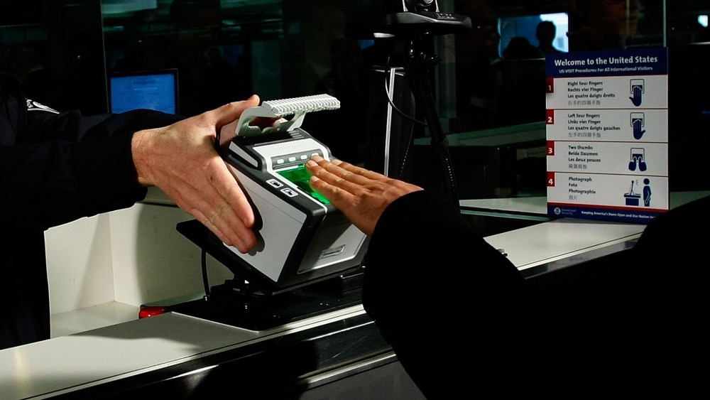 International airline passengers are fingerprinted on all ten fingers by a U.S. Customs and Border Protection officer on arrival at Dulles International Airport, Dec. 10, 2007 in Sterling, Va. (Photo by Win McNamee/Getty)