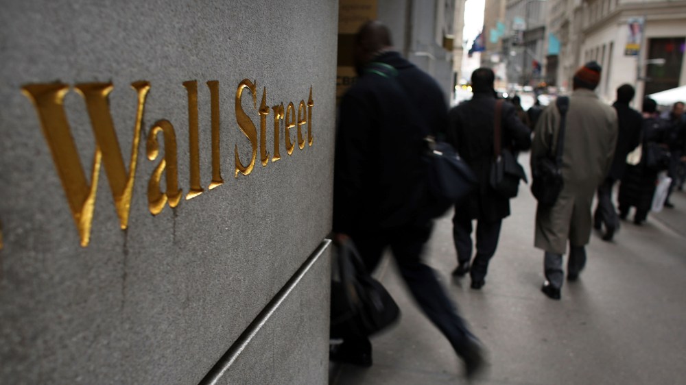 People walk down Wall Street in New York City. (Photo by Spencer Platt/Getty)