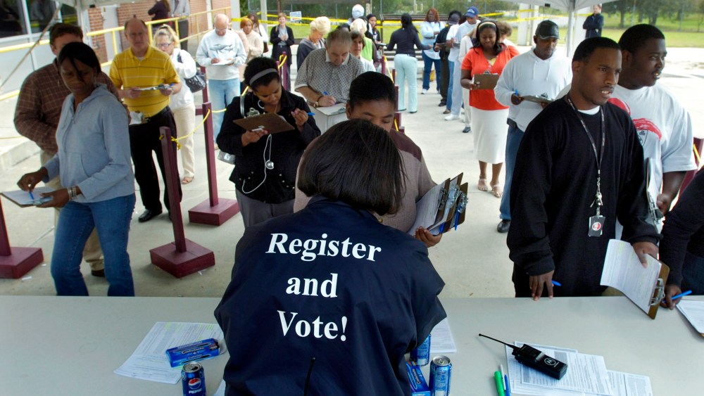 Board of Elections Customer Service Supervisor Sabrina German hands out absentee ballots during early voting Oct. 23, 2008 in Savannah, Ga. (Photo by Stephen Morton/Getty)