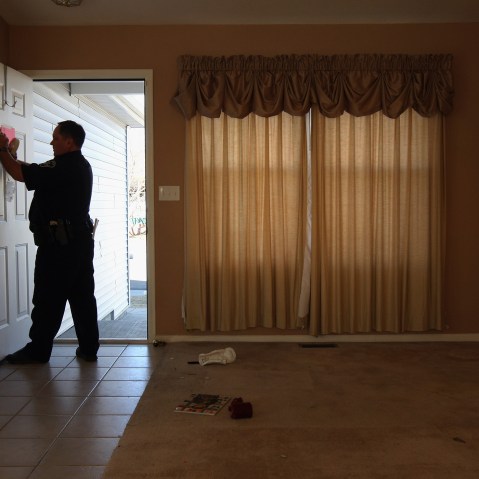 A sheriff's deputy tapes a "no trespass order" on the front door of a home, Feb. 18, 2009 in Longmont, Colo.  (Photo by John Moore/Getty)
