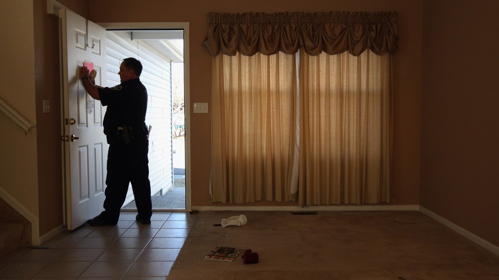 A sheriff's deputy tapes a "no trespass order" on the front door of a home, Feb. 18, 2009 in Longmont, Colo.  (Photo by John Moore/Getty)
